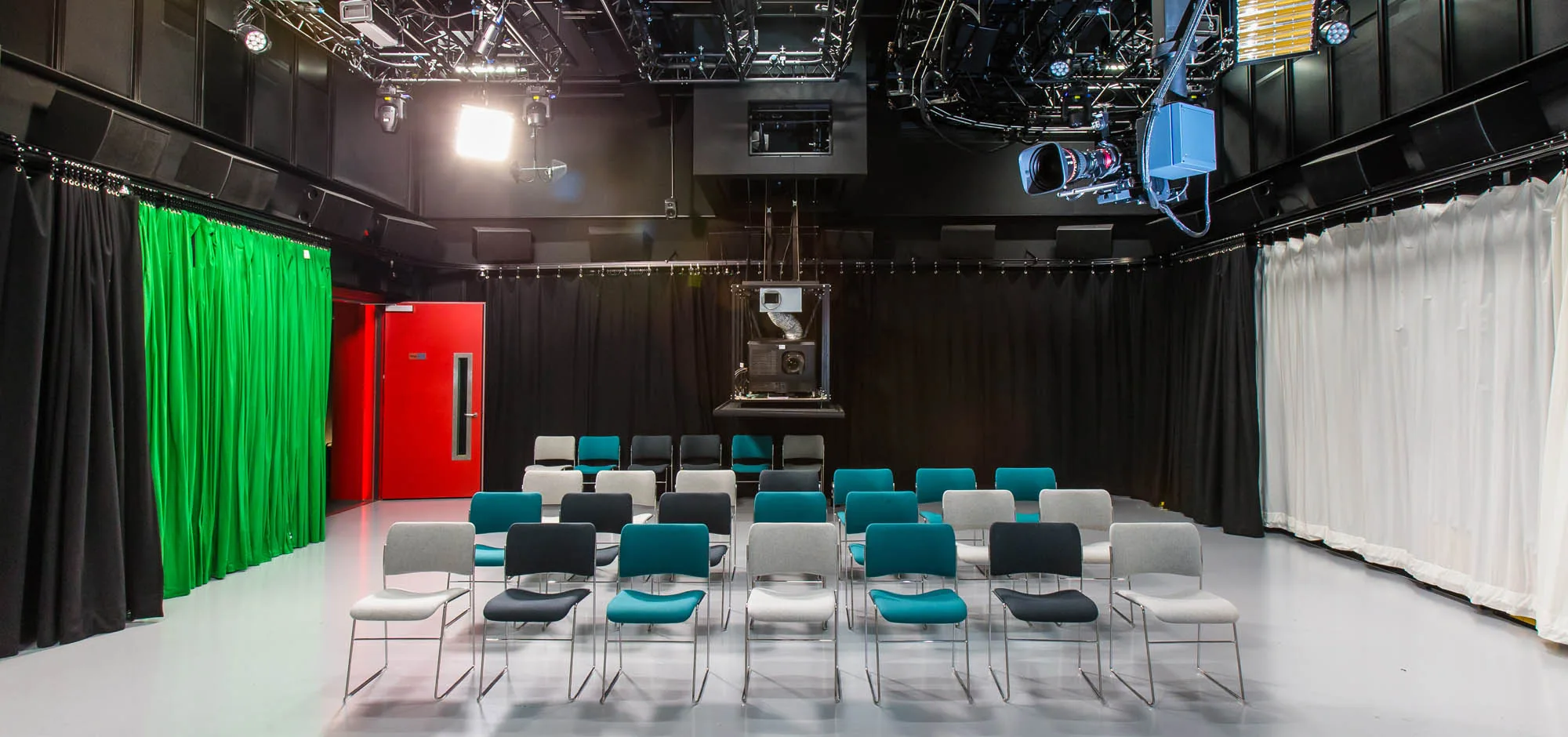 Black box production studio with green screen, lighting rig and robotic camera